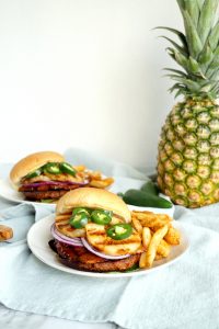 vegan aloha burgers on plates with fries