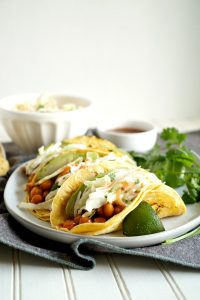 BBQ chickpea tacos topped with coleslaw and avocado on a plate