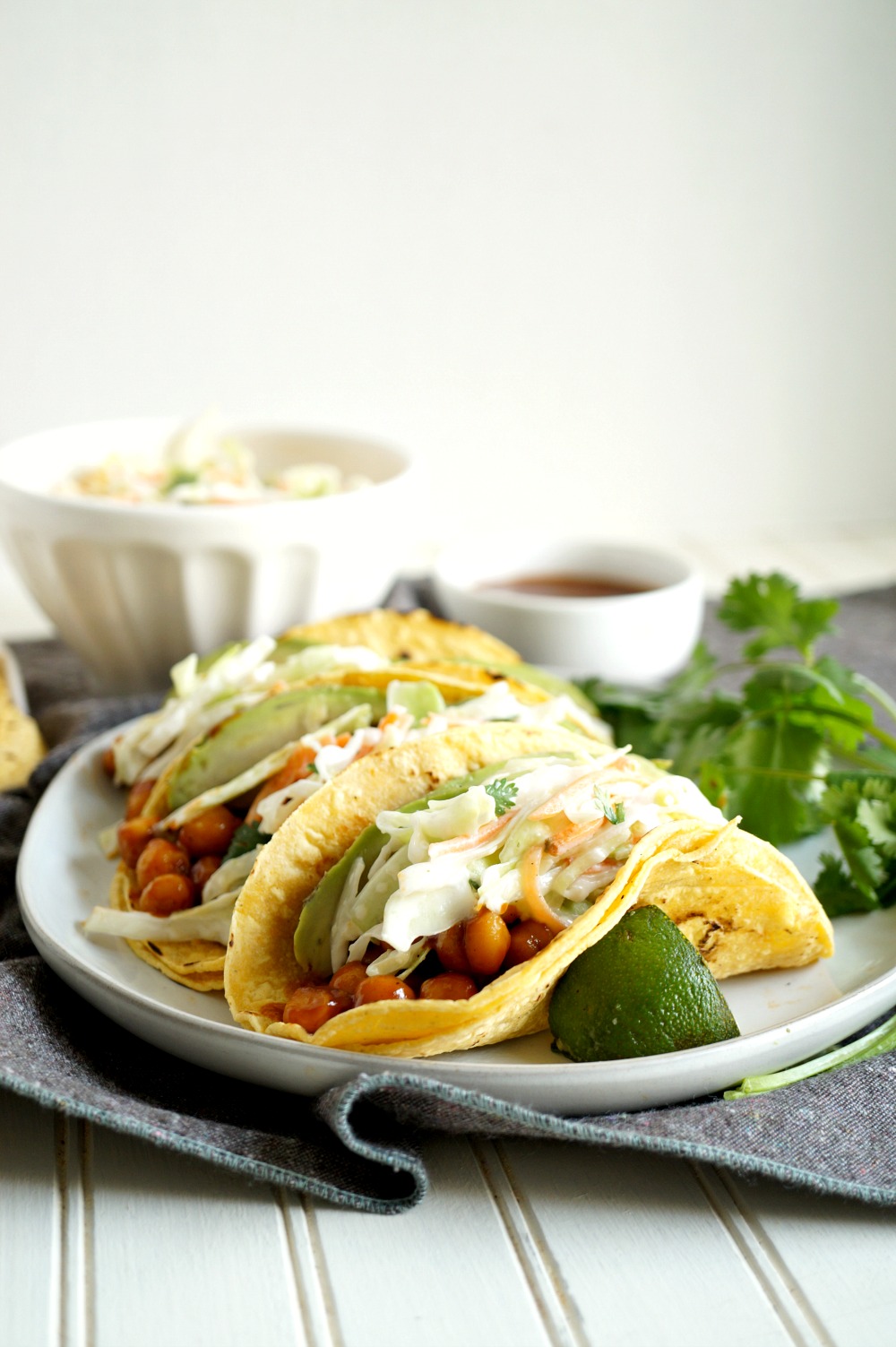 BBQ chickpea tacos topped with coleslaw and avocado on a plate