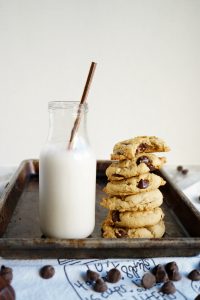 stack of vegan chocolate chip cookies next to bottle of milk
