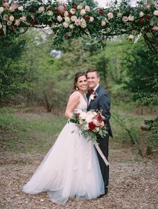 bride and groom under the floral arch