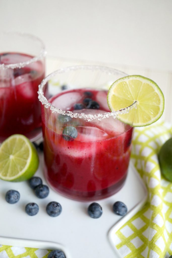 peering into a glass of blueberry margarita