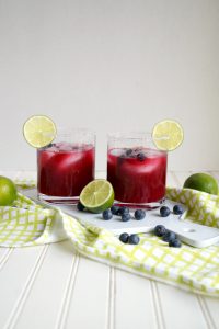 two glasses of blueberry lime margaritas