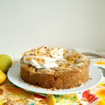 mango coconut cake on plate with cream on top