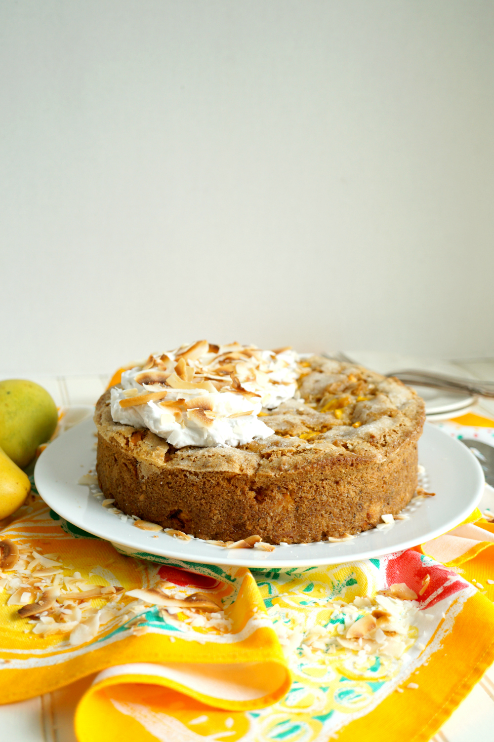 mango coconut cake on plate with cream on top