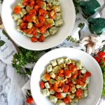 two plates of spinach gnocchi with tomato sauce