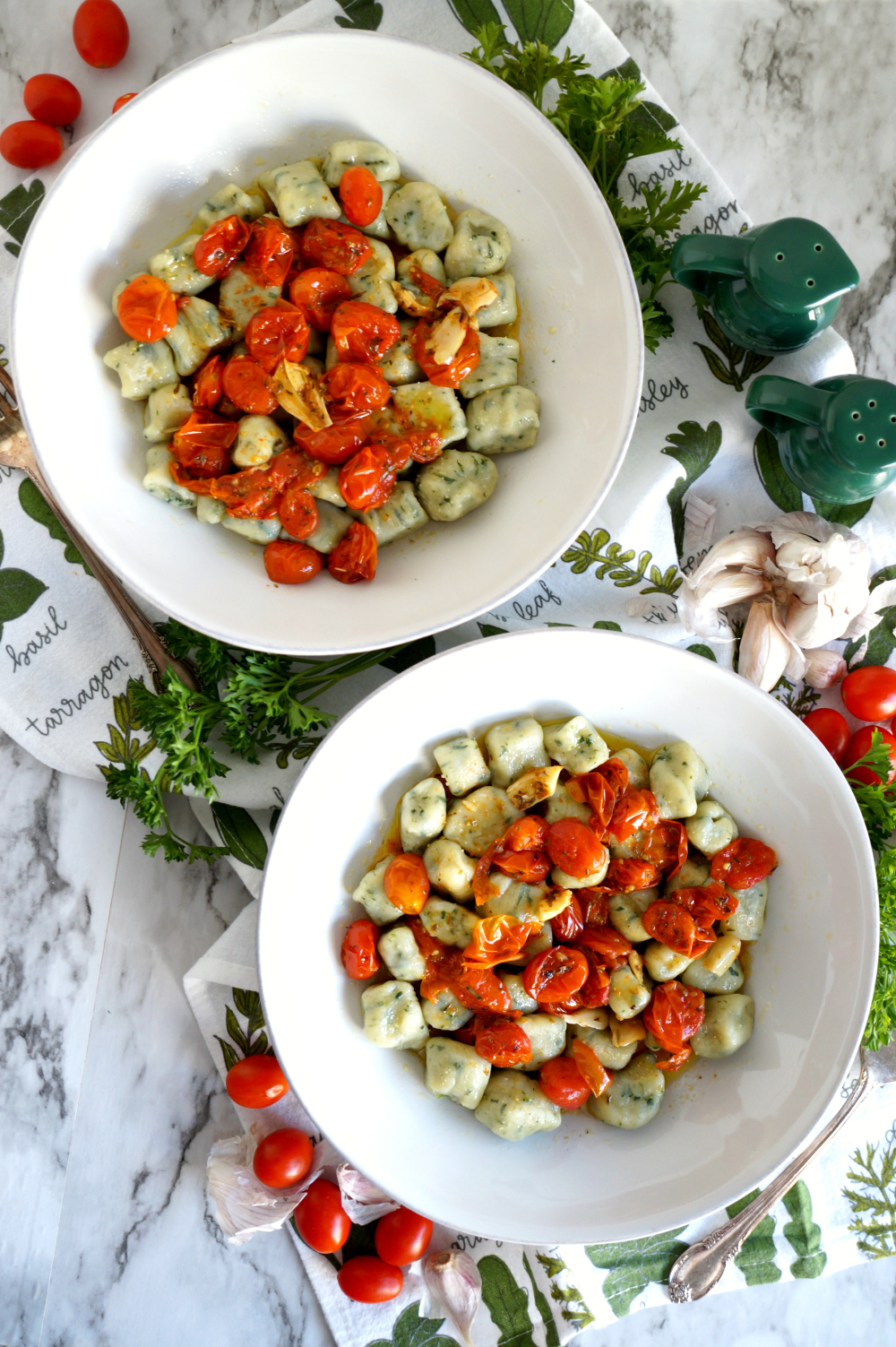 two plates of spinach gnocchi with tomato sauce