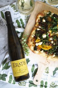 overhead shot of wine bottle and pizza