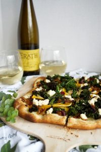 pizza with wine bottle in the background