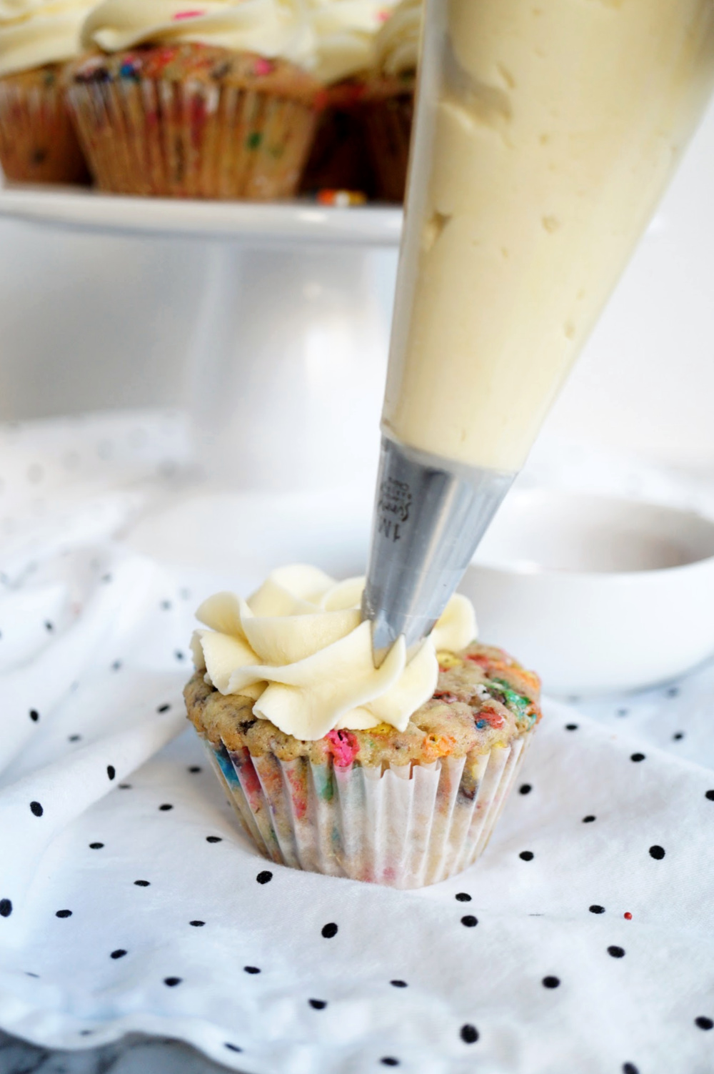 frosting a vanilla cupcake