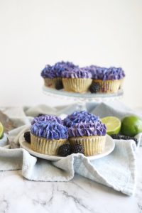 vegan blackberry lime cupcakes on a plate and on stand