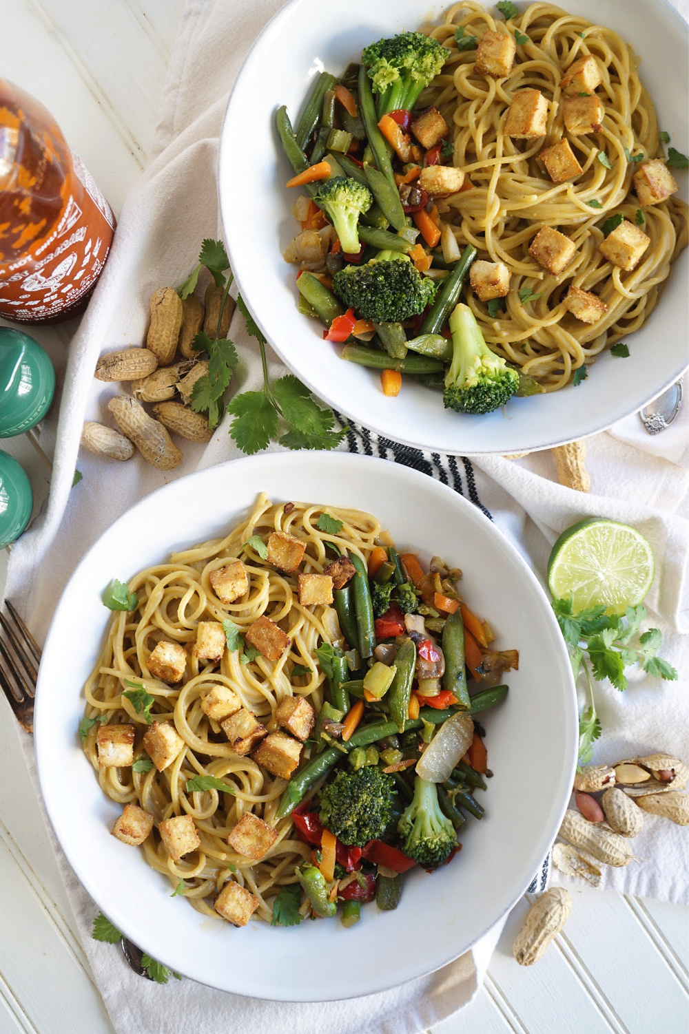 overhead shot of two bowls of peanut noodles