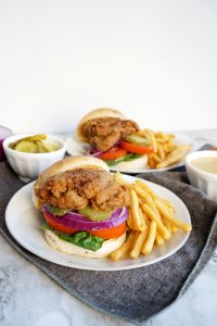 fried chick'n oyster mushroom sandwich on plate with fries