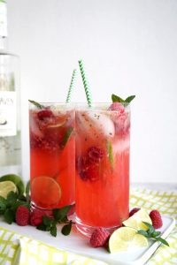 two glasses of raspberry coconut mojitos on tray