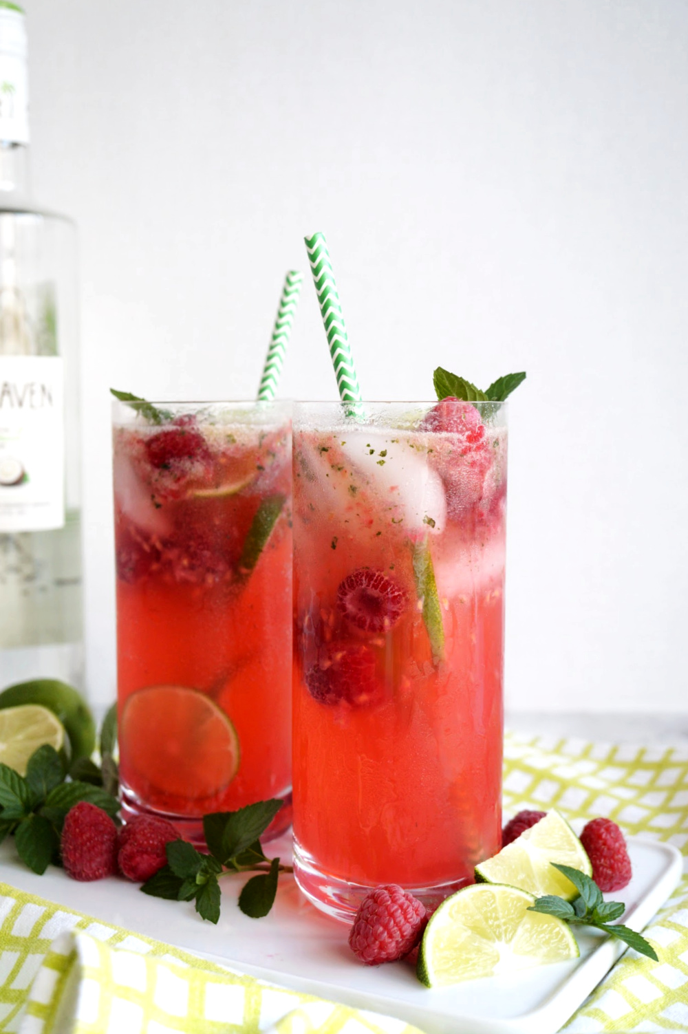 two glasses of raspberry coconut mojitos on tray