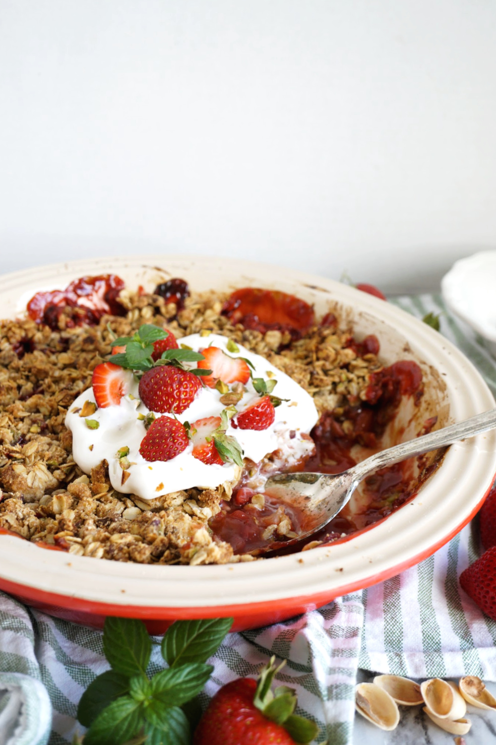 dish of strawberry pistachio crisp with serving spoon