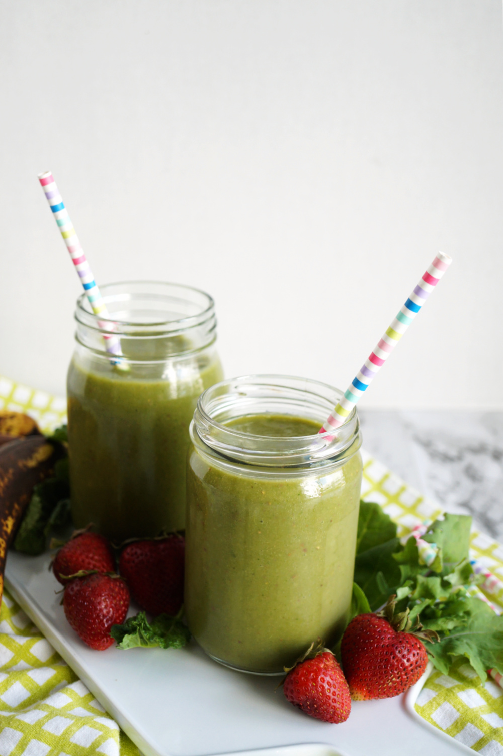 close up of two mason jars filled with green smoothie drink