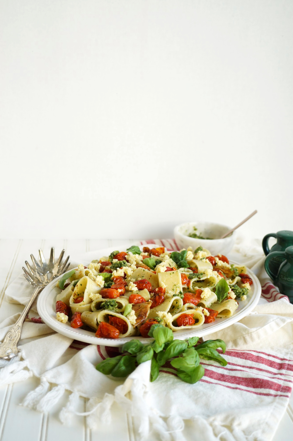 panoramic shot of plate of pesto pasta with roasted tomatoes