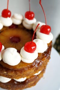 close up of cherries on top of pineapple cake