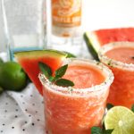 cup of watermelon mint frozen margarita with a wedge of watermelon