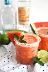 cup of watermelon mint frozen margarita with a wedge of watermelon