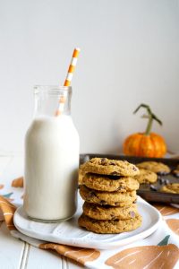 stack of pumpkin cookies with bottle of milk