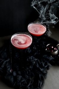 overhead angled shot of two glasses of cherry cocktail