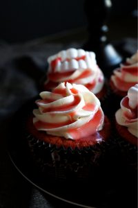 red cherry cupcake with frosting and cherry juice on top