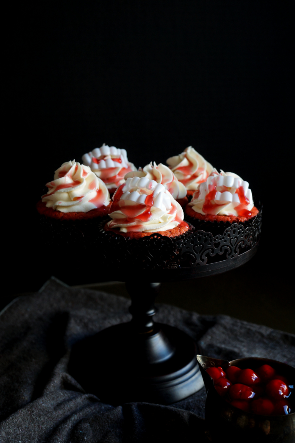 red cupcakes with cherry juice drip and plastic vampire teeth