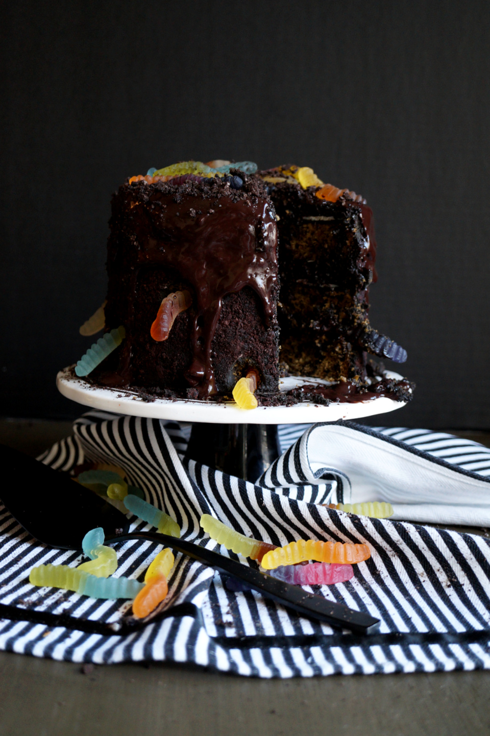 dirt and worms cake with slice cut on cake stand