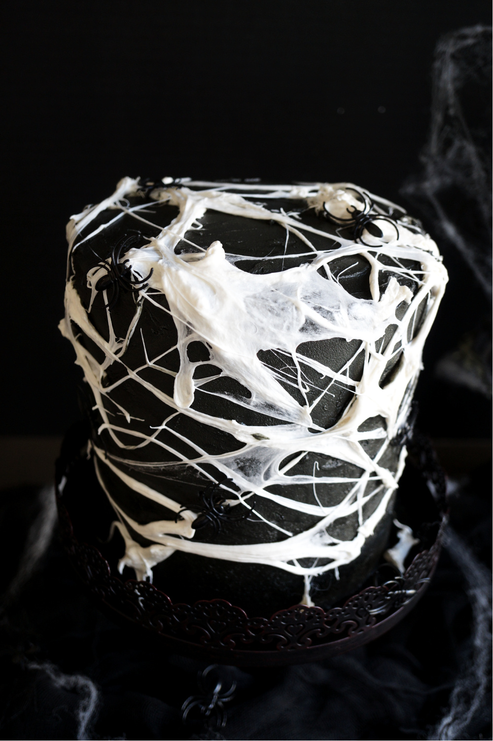 angled shot of marshmallow spiderweb on cake