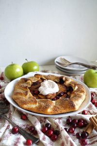apple cranberry galette on plate with whipped cream