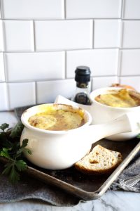 two bowls of french onion soup on pan