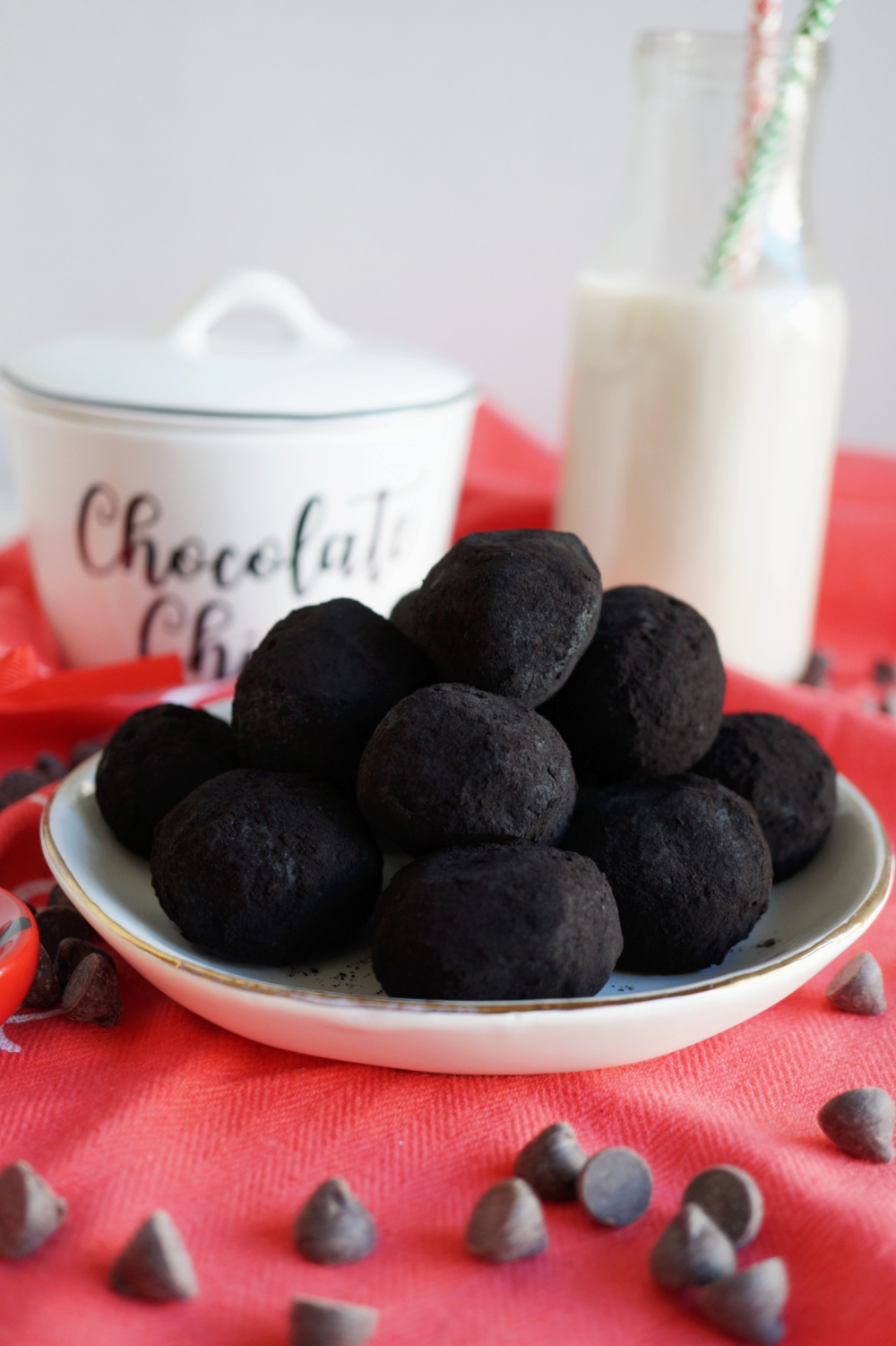 black cocoa truffles on white plate with red towel