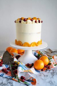 cranberry clementine cake on white cake stand