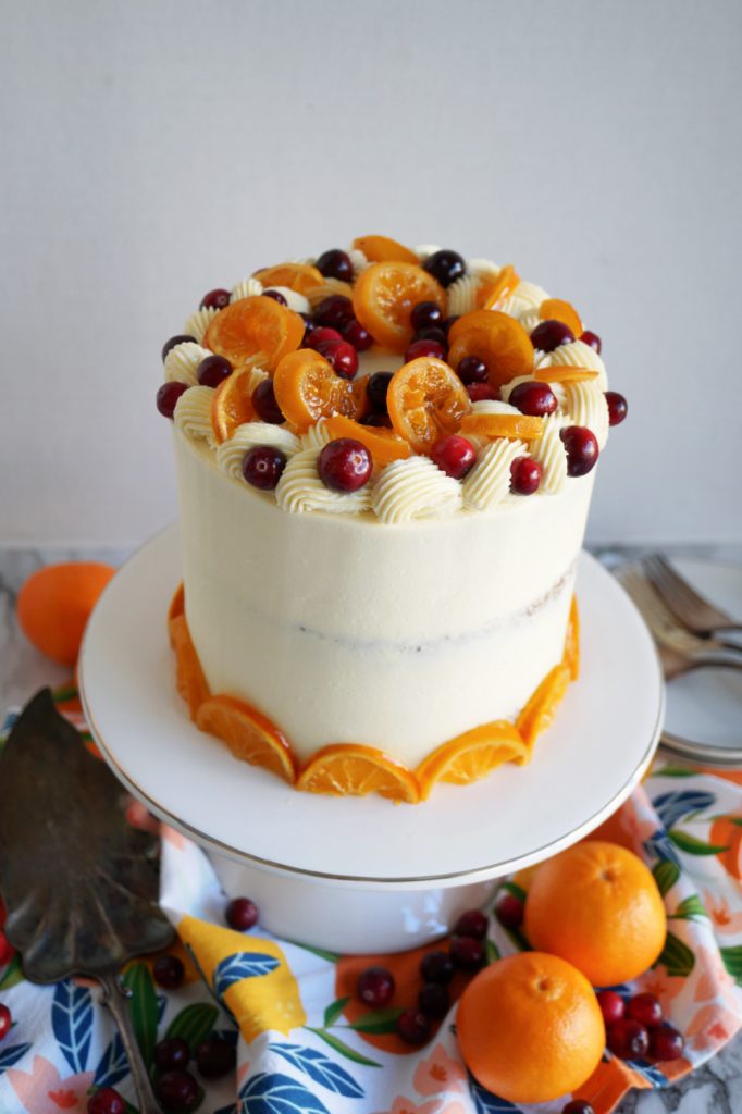 angled shot of top of cranberry clementine cake with candied citrus slices