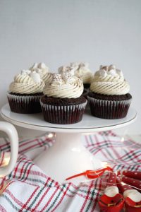 three hot cocoa cupcakes on cake stand