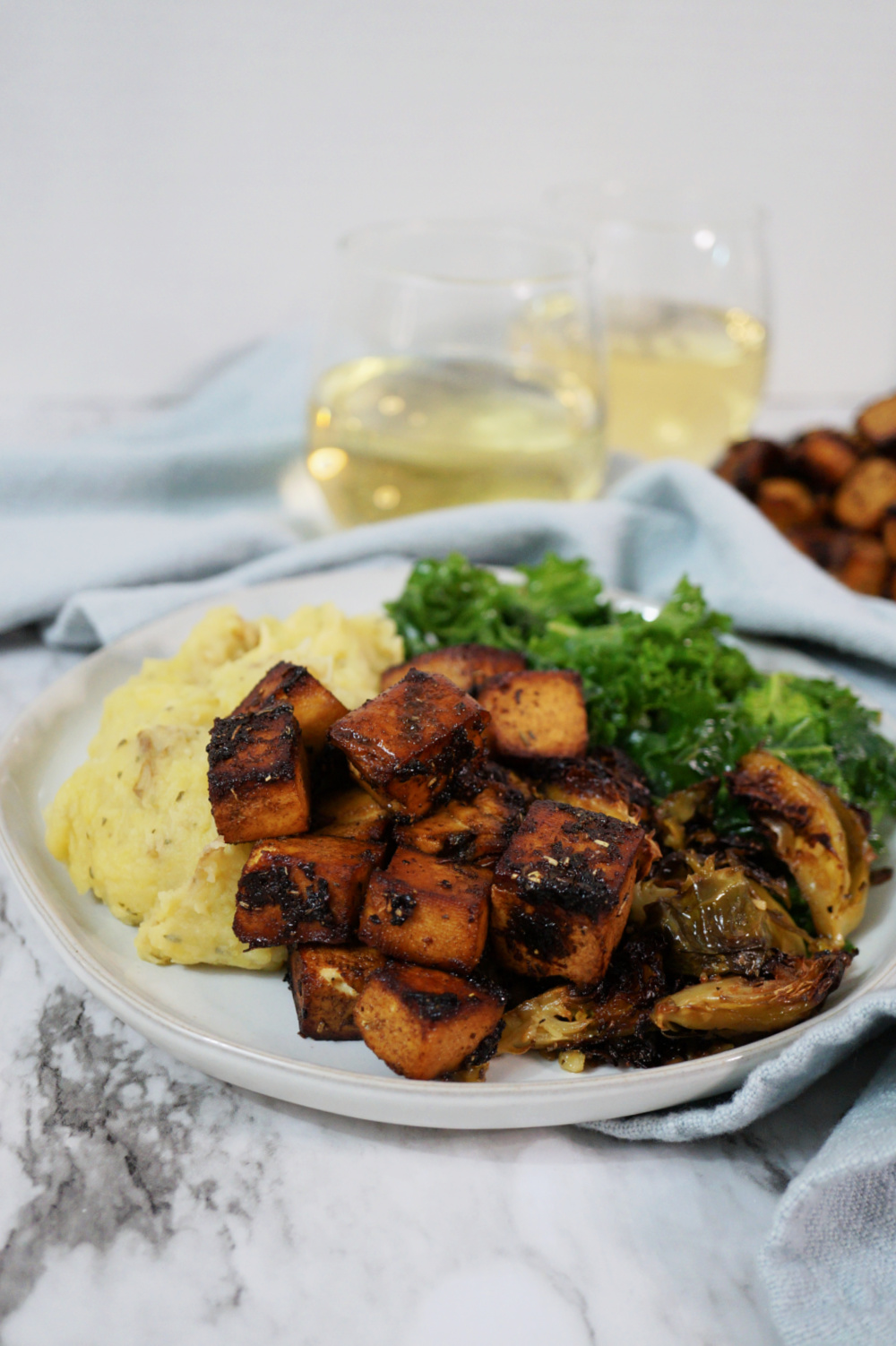 balsamic herb tofu on a plate with mashed potatoes and kale salad
