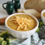 bowl of broccoli cheese soup with shredded cheese on top