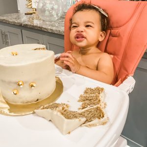 smiling baby with a smashed slice of cake