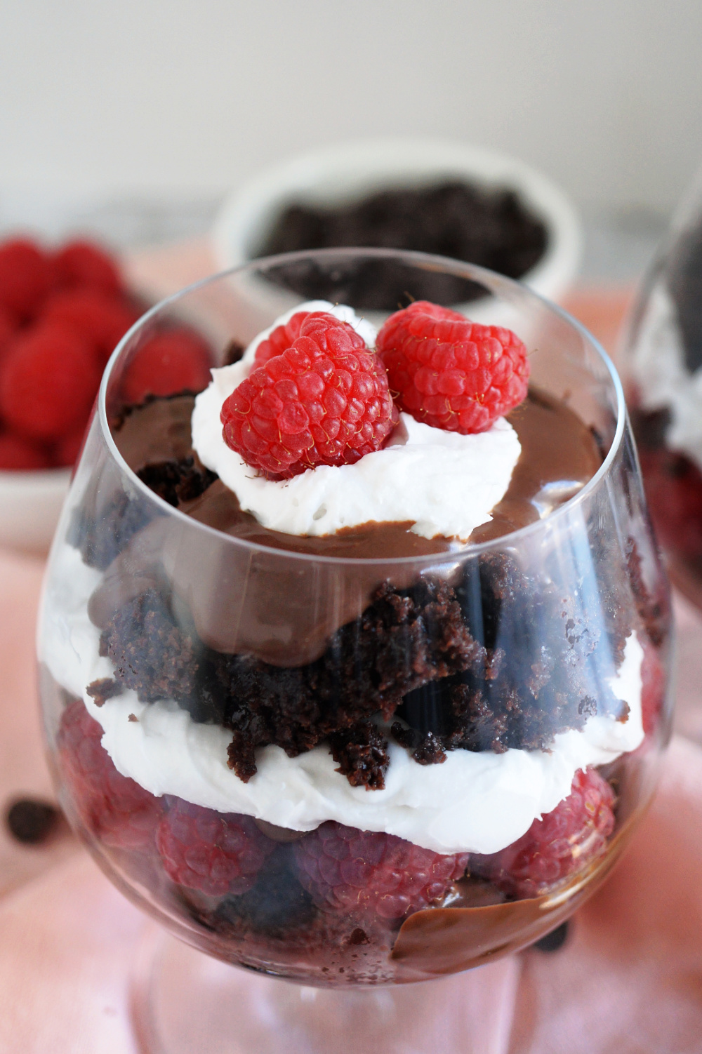 close up of raspberries and whipped cream on parfait