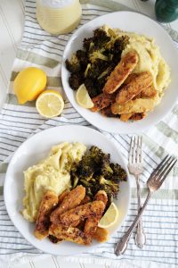 overhead shot of plates of lemon pepper tempeh with mashed potatoes and broccoli