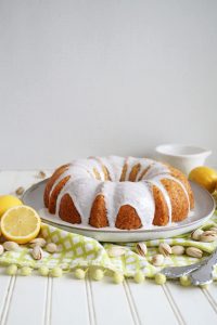 frosted lemon pistachio bundt cake on plate