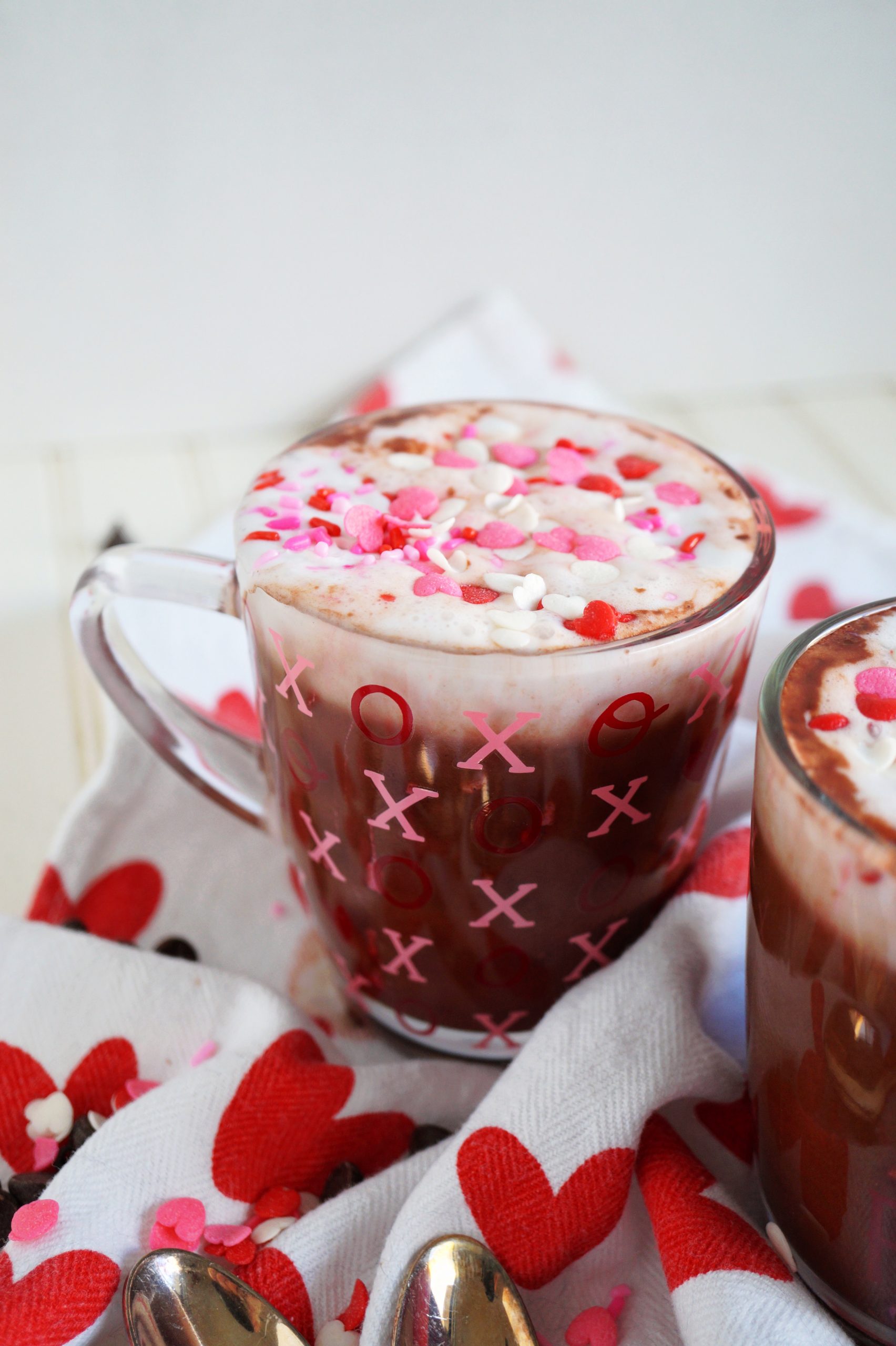 angled shot of colorful sprinkles on top of a cup of cocoa