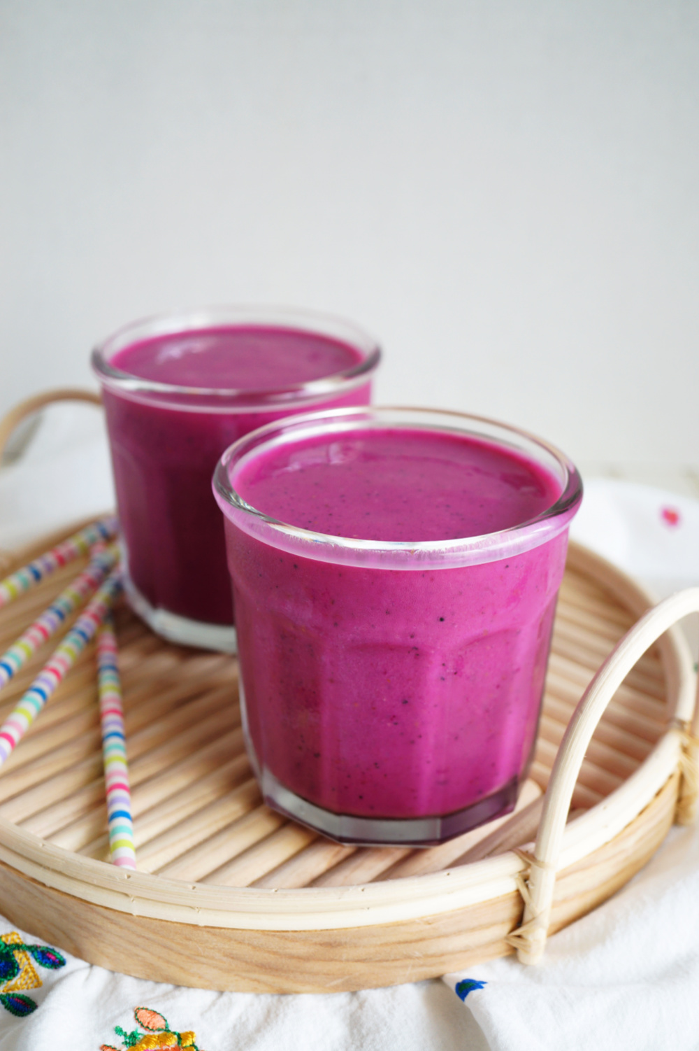two glasses of pink smoothie on tray
