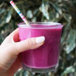 hand holding a pink pitaya protein smoothie cup