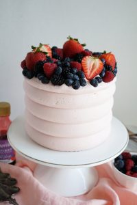 close up of berry cake on stand
