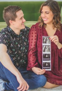 couple smiling and holding baby ultrasound